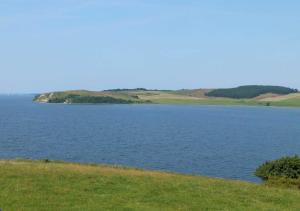 a large body of water with a grassy field at Haus an der Düne WE 05 in Lobbe +21 photos