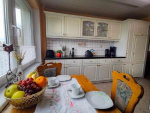 a kitchen with a table with a bowl of fruit at Ferienhaus Voss in Alt Zauche