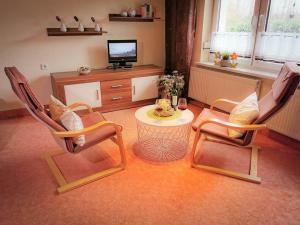 a living room with two chairs and a table and a tv at Ferienhaus Voss in Alt Zauche