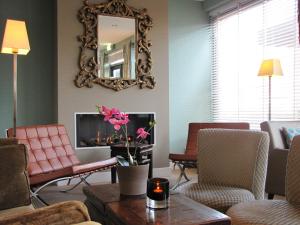 ein Wohnzimmer mit Kamin und Spiegel in der Unterkunft Hotel Gulpenerland in Gulpen-Wittem