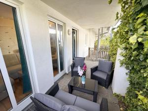 a patio with chairs and a table with flowers on it at Villa Linde Whg 23 mit Terrasse in Göhren