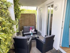 a patio with chairs and a table with flowers on it at Villa Linde Whg 23 mit Terrasse in Göhren