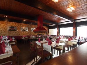 a restaurant with tables and chairs with red napkins at Hotel Restaurant Margaretenhof in Überherrn