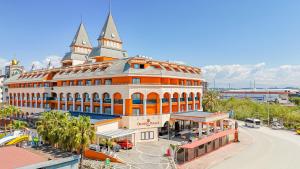 an orange and white building with two towers on a street at Orange Palace Side - All Inclusive in Side