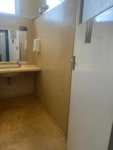 a bathroom with a door and a sink and a mirror at The Victoria Hotel in Collie +35 photos