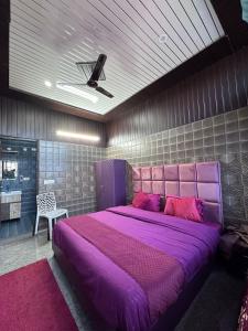 a bedroom with a large purple bed with a ceiling at Bella Vista Hotel & Home Stay in Mussoorie