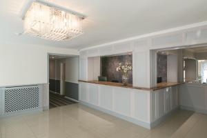 a lobby with a counter with a vase of flowers at Celtic International Hotel Cardiff Airport in Barry