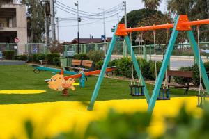 a playground with swings in a park at New Olivka House in Anavyssos
