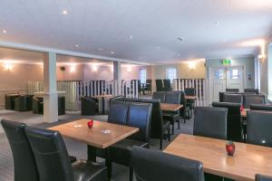 Celtic International Hotel Cardiff Airport في باري: غرفة طعام مع طاولات وكراسي خشبية