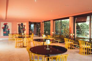 a restaurant with tables and chairs and windows at Topazio Vibe Beach Hotel & Apartments - Adults Friendly in Albufeira