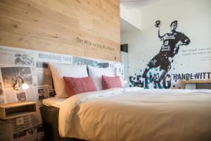 a bedroom with a bed with a football player on the wall at Hotel Alte Post Flensburg in Flensburg +73 photos