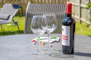 a bottle of wine and two wine glasses on a table at Ferienhaus Robby in Stedesdorf