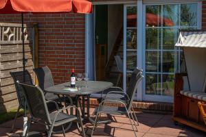 a table and chairs on a patio with a bottle of wine at Ferienhaus Robby in Stedesdorf