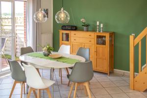 a dining room with green walls and a table and chairs at Ferienhaus Robby in Stedesdorf +55 photos