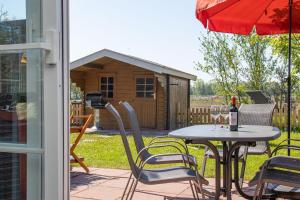 a patio with a table and chairs and a shed at Ferienhaus Robby in Stedesdorf