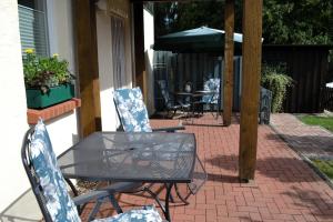 a glass table and chairs on a brick patio at Neue moderne Ferienwohnung, separater Eingang, Seenähe in Möllen