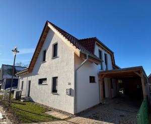 a large white building with a garage at Fleesenseetreppe rechts in Göhren-Lebbin