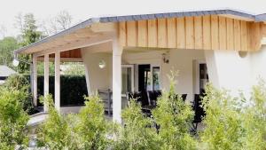 a house with a wooden roof at Bungalow am See in Basedow
