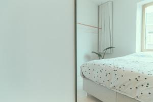 1 dormitorio con cama y espejo en AP8 city & park apartement, en Aalst