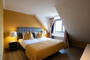 ein Schlafzimmer mit einem Bett mit zwei Kissen und einem Fenster in der Unterkunft Hotel Gulpenerland in Gulpen-Wittem