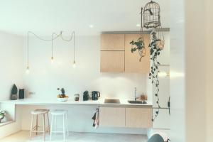 a kitchen with white cabinets and bar stools at AP8 city & park apartement in Aalst