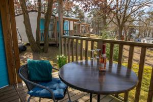 a table and chairs on a deck with a bottle of beer at Mobilheime Lagune in Lychen