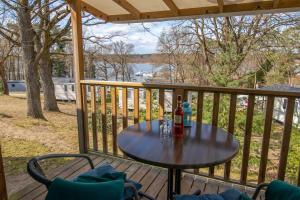 a table on a deck with a bottle of wine at Mobilheime Lagune in Lychen