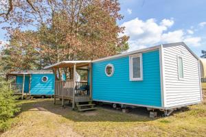 a blue and white tiny house with a porch at Mobilheime Lagune in Lychen