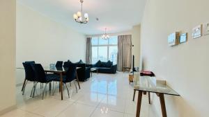 a dining room and living room with a table and chairs at Ginger Luxury House in Juffair