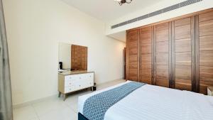 a bedroom with a bed and a wooden cabinet at Ginger Luxury House in Juffair +26 photos