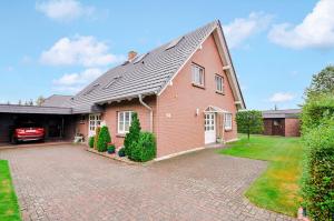 a red brick house with a car parked in the driveway at Matzlow, Fewo Voss in Garwitz