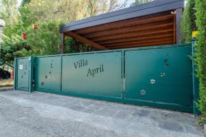 a blue fence with the words village april on it at April in Caleri