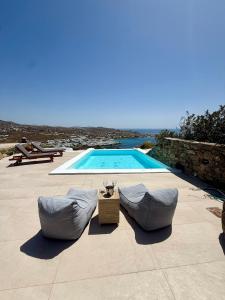 a swimming pool with two bean bags next to at Villa Ocean prince in Mikonos