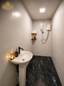 a bathroom with a sink and a shower at The Cage Suites in Bangkok +59 photos