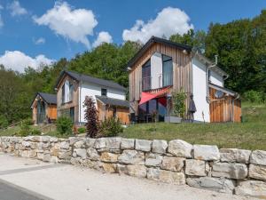 a house with a stone wall in front of it at Panoramabungalow DHH in Obernsees