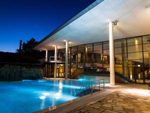 a large building with a swimming pool at night at Panoramabungalow Typ 70 in Truppach