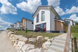 a row of houses on a hill with a stone wall at Panoramahaus Premium Typ 100 in Truppach