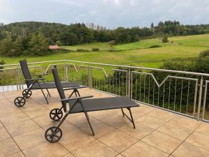 two chairs and a table on a balcony with a view at Ferienwohnung Waldesrand in Rodenbach