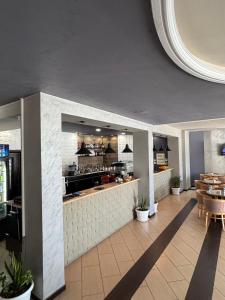 a restaurant with a kitchen with tables and chairs at BAR RESTORANT HOTEL ALPET Elbasan in Elbasan