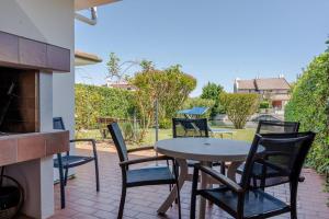 a patio with a table and chairs and a fireplace at Margareta in Caleri