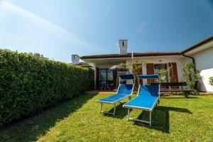 a group of blue chairs in the yard of a house at Margareta in Caleri