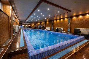 ein großer Swimmingpool in einem Hotelzimmer in der Unterkunft Prezident Hotel Novi Sad - Outdoor Pool & Spa in Novi Sad