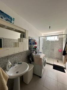 a bathroom with a sink and a washing machine at Suc Valley in Klos