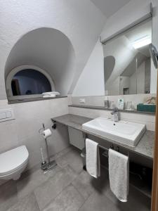 ein Badezimmer mit Waschbecken, Toilette und Spiegel in der Unterkunft Hotel Prinz in München + 133 Fotos
