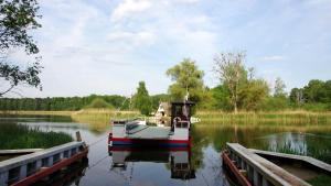 a boat docked at a dock on a lake at Ferienhaus in Teterow