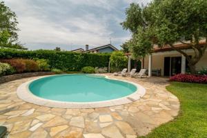a swimming pool in a yard with chairs and a house at D Oro in Caleri