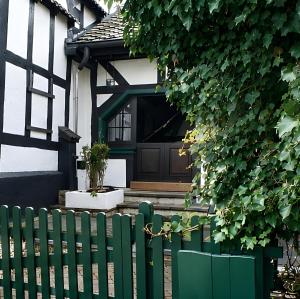 a green fence in front of a house at Ferien im Kellisch-Haus in Schalkenmehren