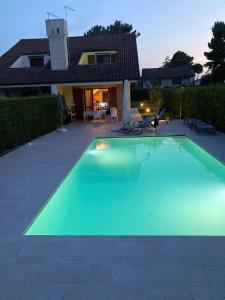 a swimming pool in front of a house at Fortuna in Palazzo Vianello