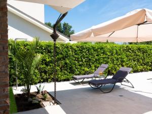 two chairs and an umbrella on a patio at Fortuna in Palazzo Vianello