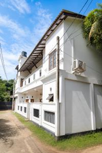a white house with a white fence at Princess Rose Villa in Vavuniya